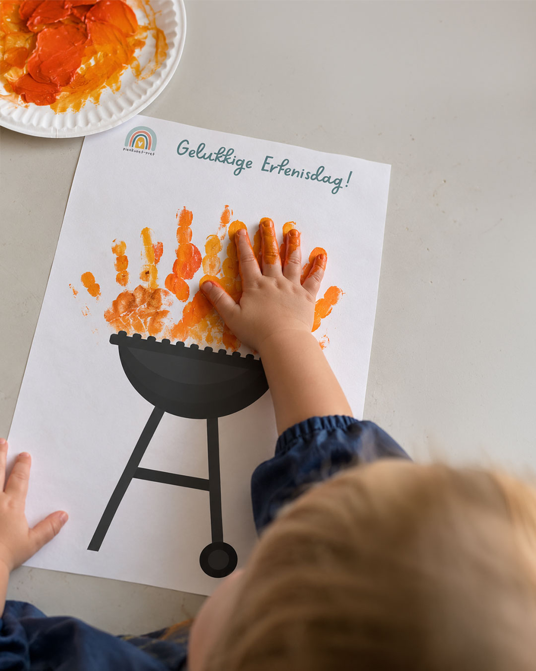 Kind maak 'n handafdruk-vlam bo-op 'n braai-tekening